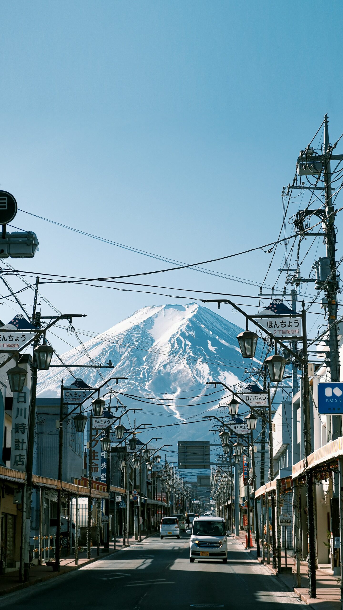 Conduire au Japon avec un permis étranger : le guide complet 2026 🗾 7 Voiture dans une rue japonaise avec le mont Fuji en arrière-plan — road trip Japon conduire au Japon